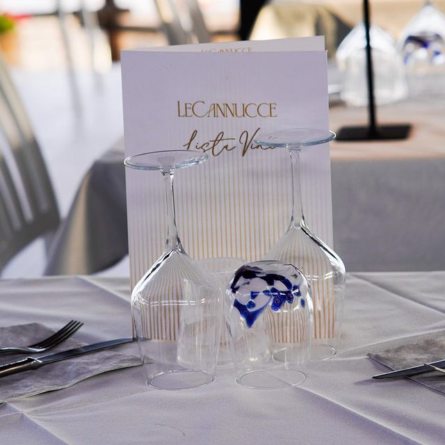 Table set at Il Bagno Le Cannucce, menu visible.
