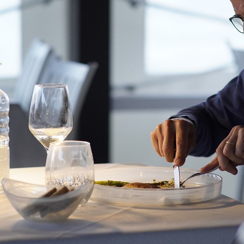 Person dining in an elegant restaurant, table set.